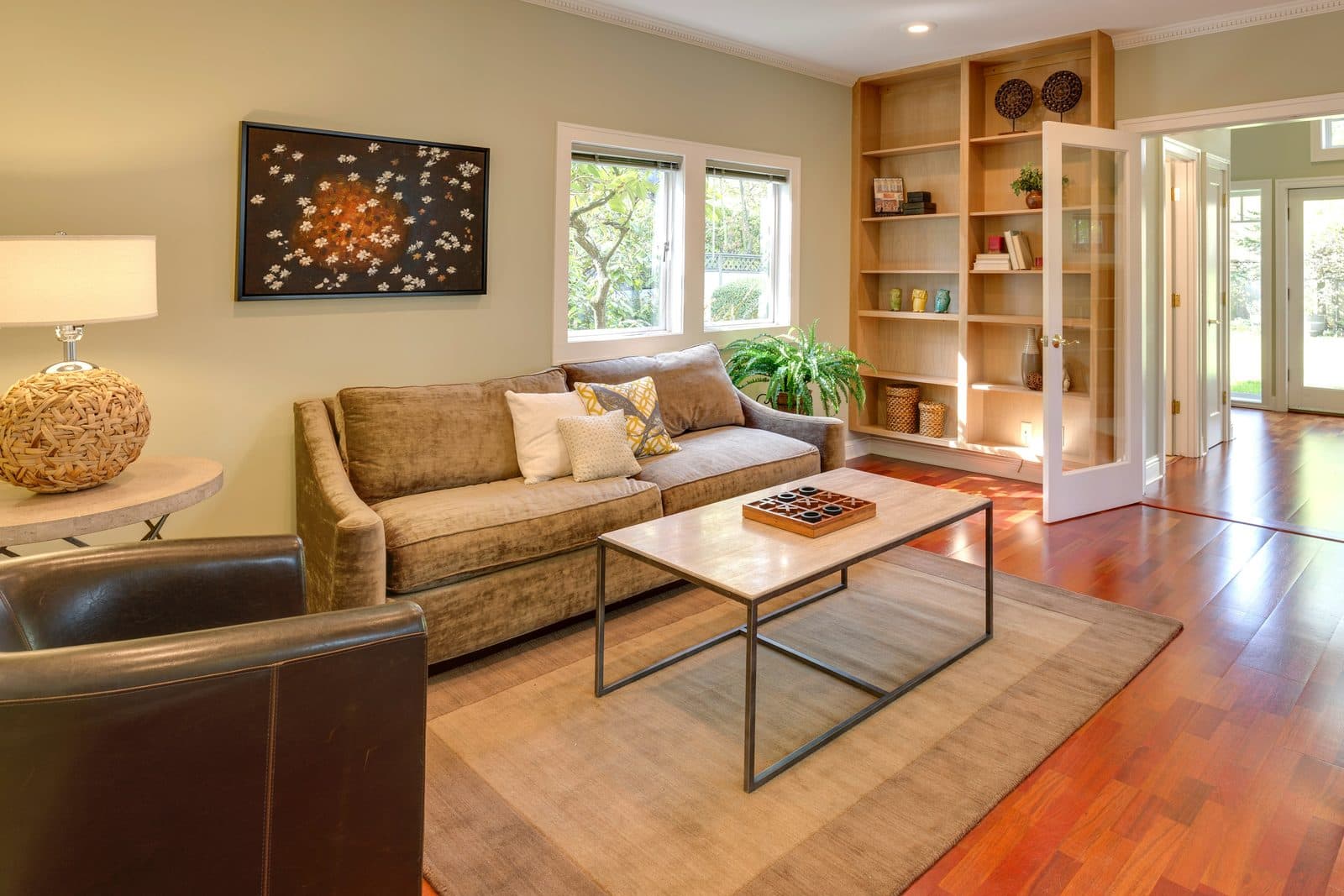 A sunny living room with a sofa and bookshelves