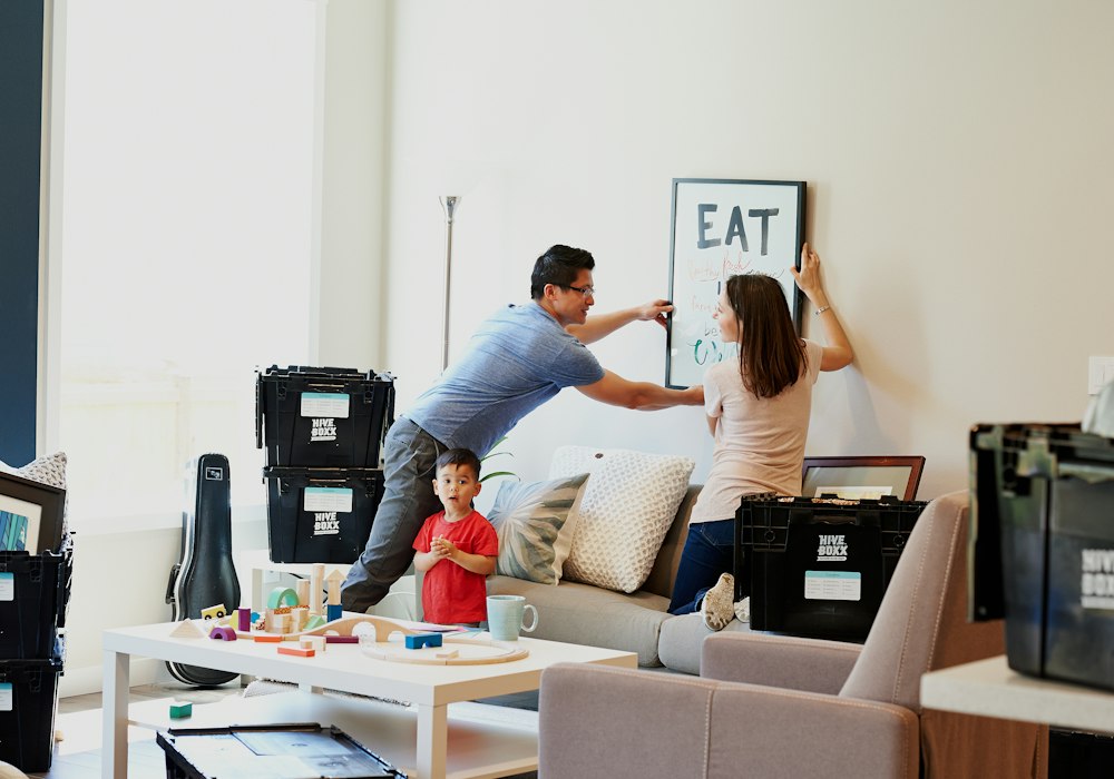 A family hanging a sign in their new home