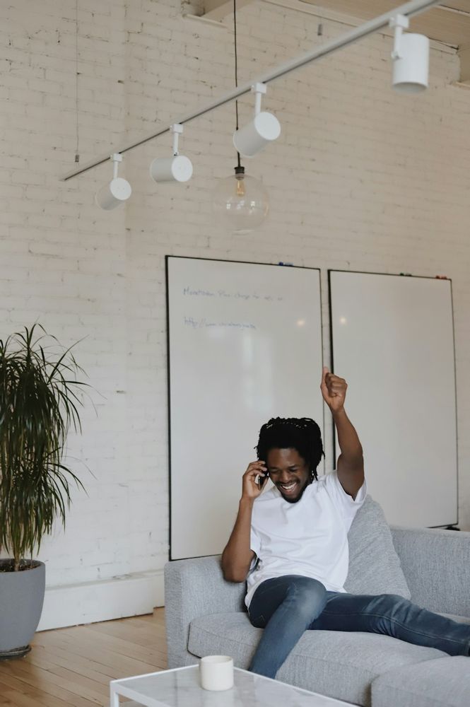 A man laughing on a phone call at home
